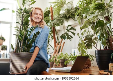 Ecofriendly Businesswoman Furnishing Her Place Of Work With Houseplant