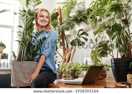 Ecofriendly businesswoman furnishing her place of work with houseplant