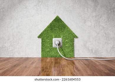 Eco-friendly electricity at home concept. Electric outlet on wall and grass in shape of house. Sustainable energy source concept. - Shutterstock ID 2261604553
