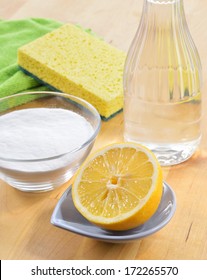 Eco-friendly natural cleaners. Vinegar, baking soda, salt, lemon and cloth on wooden table. Homemade green cleaning.
