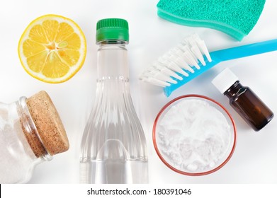 Eco-friendly natural cleaners. Vinegar, baking soda, salt, lemon and essential oil. Homemade green cleaning on white background.