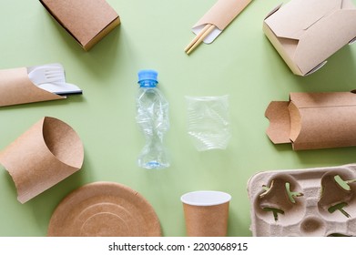 Eco-friendly Paper Utensils And Packaging Lie Around Plastic Trash On A Green Background. View From Above. The Concept Of Refusing To Use Plastic.