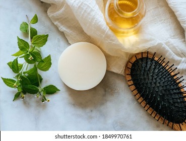 Eco-Friendly Solid Shampoo Bar Hair Care Product With Argan Oil Laying On A Marble Background.