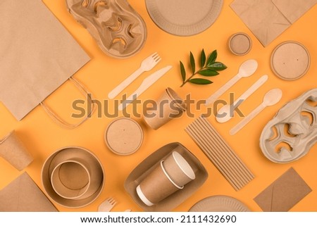 Eco-friendly tableware - kraft paper food packaging on yellow or orange background. Street food paper packaging, recyclable paperware, zero waste packaging concept. Flat lay, mockup image