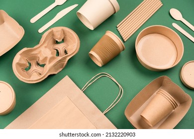 Eco-friendly tableware - kraft paper utensils on green background. Paper cups and containers, wooden cutlery. Street food paper packaging, recyclable paperware, zero waste packaging. Mockup, flat lay - Shutterstock ID 2132220903