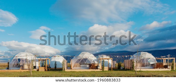 eco-hotel glamping in a wonderful location with\
clouds.  Green, blue,  background. Cozy, camping, glamping,\
holiday, vacation lifestyle concept. Outdoors cabin, scenic\
background. Georgia
