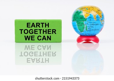 Ecological concept. On a reflective surface is a globe and a green sign with the inscription - Earth Together We Can