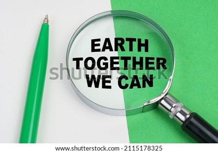 Ecological concept. On a white-green background lies a pen and a magnifying glass, inside which is the inscription - Earth Together We Can
