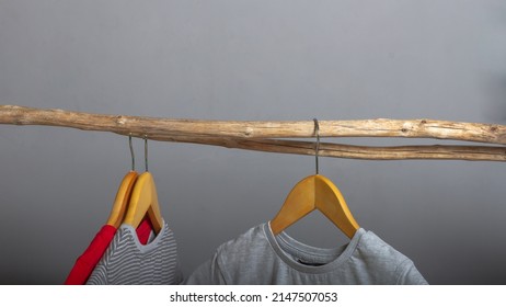 Ecological concept in the production and storage of clothing, T-shirts made of natural cotton on wooden hangers on a gray background. - Powered by Shutterstock