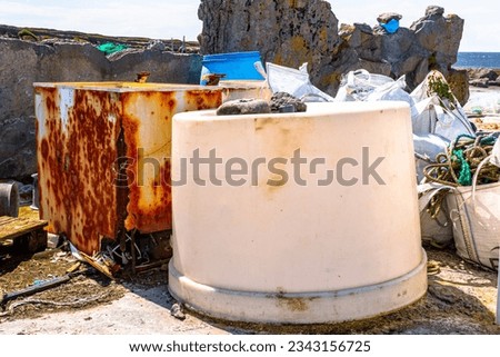 Ecological damage with environmental pollution on coastal, accumulation of equipment, washing machine, industrial refrigerator, bags with strings, debris and garbage on island of Inis Oirr, Ireland