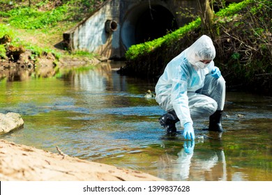 ecological disaster, contaminated water comes out of the sewage system - an ecologist takes a sample of water for research - Shutterstock ID 1399837628