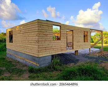 Ecological house under construction with recycled materials and wooden facade. Sustainable house construction frame under tropical blue sky. Architecture and construction in the French Antilles.