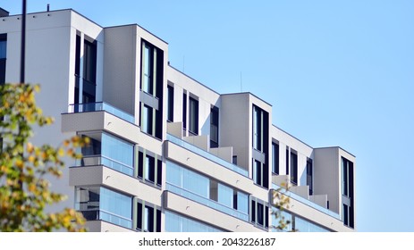 Ecological housing architecture. A modern residential building in the vicinity of trees. Ecology and green living in city, urban environment concept. Modern apartment building and green trees.