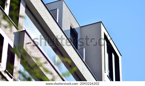 Ecological housing architecture. A modern\
residential building in the vicinity of trees. Ecology and green\
living in city, urban environment concept. Modern apartment\
building and green\
trees.