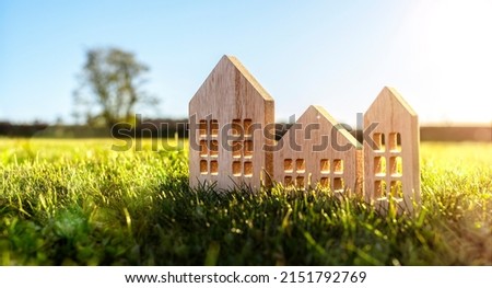 Ecological wood  model house in empty field at sunset concept for construction and real estate