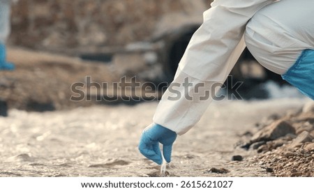 Ecologist sampling water from the river with test tube, Biologist wear protective suit and mask collects sample of waste water from industrial, problem environment, scientist environmentalist