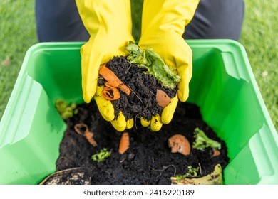 Ecology compost supply Kitchen waste recycling composter environmentally friendly. The young man throws leftover fruit peel egg shell and vegetables reduce waste - Powered by Shutterstock