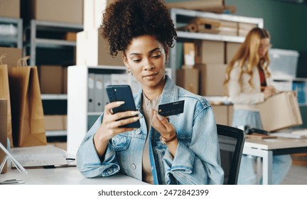 Ecommerce, black woman and smartphone in warehouse for sales, shopping and checkout with credit card. Female entrepreneur, stock and small business with payment for orders, logistics and trade online - Powered by Shutterstock