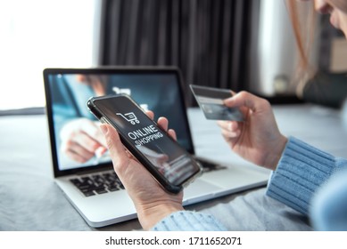 E-commerce And Online Shopping Concept, Woman Hand Using Smartphone And Laptop (Mockup Website) And Holding Credit Card For Shopping Payment Online At Home.