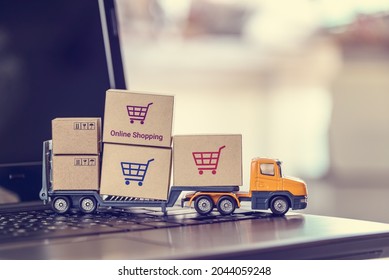 Ecommerce, online shopping and delivery service concept : Boxes with shopping carts on a trailer truck on a laptop, depicts e-commerce impacts the trucking industry that retailer needs fast, low price - Shutterstock ID 2044059248