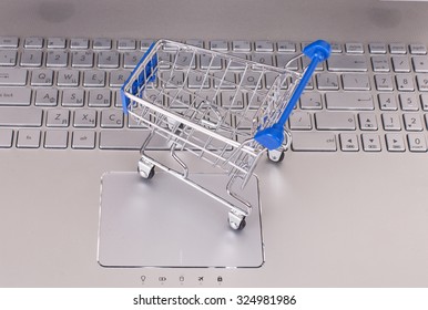 E-commerce. Shopping cart with cardboard boxes on laptop. The concept of online shopping store. - Stock image