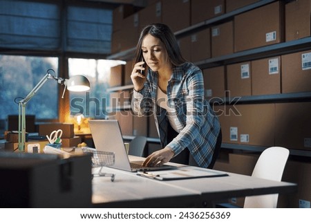E-commerce store owner taking orders on the phone and talking to customers