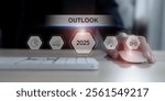 Economic, business outlook concept. Financial, business view or economic growth forecast for 2025. Businessman working on laptop with OUTLOOK 2025 text and business trend icons on virtual screen.