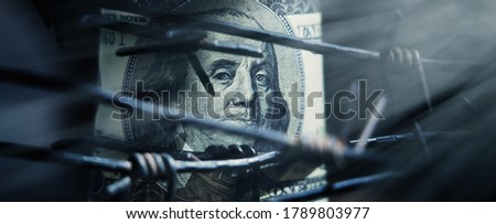 Economic confrontation and warfare, sanctions and embargo busting concept. Barbed wire against US Dollar bill. Horizontal image.