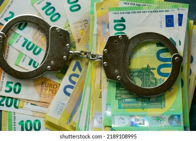 Economic Crimes.Arrest On Bank Accounts And Property . Corruption And Waste Of The Budget In The European Union.Handcuffs,euro Bills On Black Chalkboard Background.Taking Bribes And Punishing