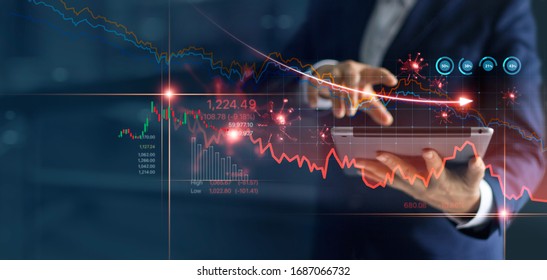 Economic crisis, Businessman using tablet analyzing sales data and economic graph chart that is falling due to the corona virus crisis, Covid-19, stock market crash caused. 