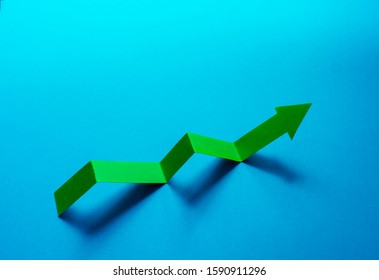 Economic Growth Concept. Green Arrow Pointer Up Graph On Blue Background.