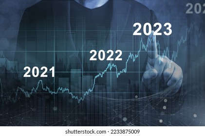 economic recovery after falling due to inflation, stagnation, recession, 2023 financial chart. Businessman pointing graph of future growth on dark blue background - Shutterstock ID 2233875009