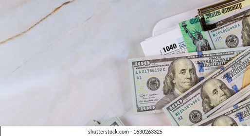 Economic Stimulus Tax Return Check And US 100 Dollar Bills Currency