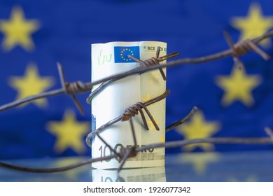 Economic Warfare, Sanctions And Embargo Busting Concept. EU Money Wrapped In Barbed Wire Against Flag Of European Union.