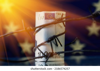 Economic Warfare, Sanctions And Embargo Busting Concept. EU Money Wrapped In Barbed Wire Against Flag Of European Union. Horizontal Image.