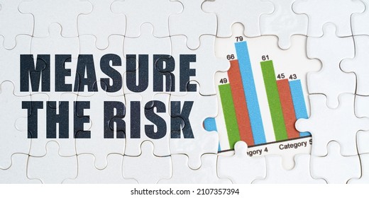 Economy And Business Concept. On White Puzzles There Is An Inscription - Measure The Risk. Financial Graph In The Window Among The Puzzles