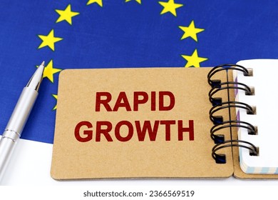 Economy and finance concept. On the flag of the European Union lies a pen and a notepad with the inscription - rapid growth. - Shutterstock ID 2366569519