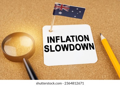 Economy and finance concept. On the table are a magnifying glass, a pencil, the flag of Australia and a sheet of paper with the inscription - inflation slowdown - Shutterstock ID 2364812671