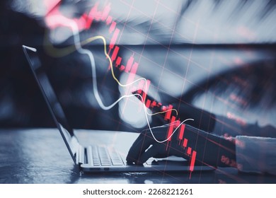 Economy recession and crisis concept with going down digital red financial chart candlestick and graphs on man hands typing on modern laptop outdoors, double exposure - Powered by Shutterstock