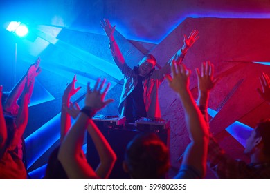 Ecstatic audience looking at dejay while dancing