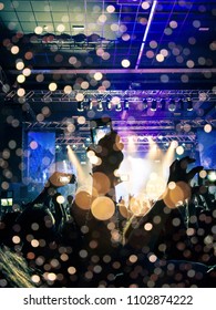 Ecstatic crowd in front of a brightly lit stage in a concert venue