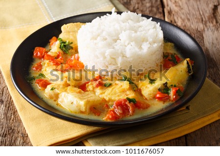 Ecuadorian cuisine: Pescado encocado or fish with coconut sauce close-up on a plate. Horizontal

