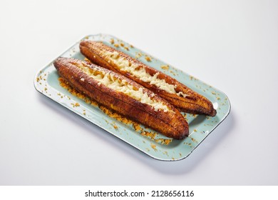 Ecuadorian maduro con queso consists of baked ripe plantains stuffed with cheese. It’s on a white background.  - Shutterstock ID 2128656116