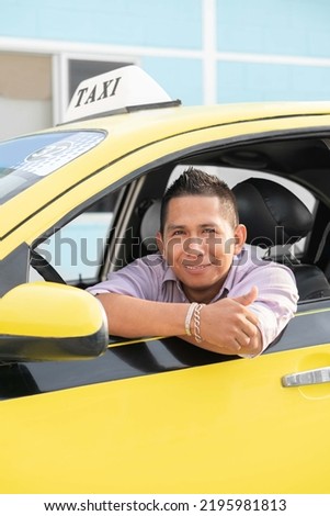 Ecuadorian taxi driver inside a yellow taxi. Latin man looking at camera. Copyspace.
