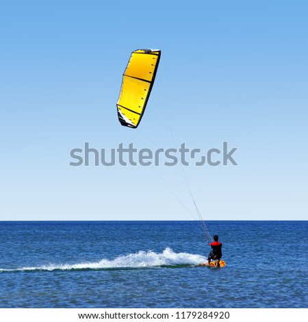 Ecume in the wake of the windsurfer.                   