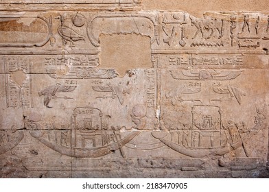 EDFU, EGYPT - MAY 08, 2013 : Engraved Raised Reliefs Including Boats And Hieroglyphics On The Pylon Wall Inside The Temple Of Horus At Edfu. The Vulture Like Figure Represents Goddess Nekhbet.