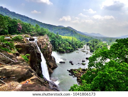 At the edge of the Athirapally Waterfall in Kerala, with a stunning view of the surrounding jungle and mountains - Kochi, India (Cochin) 
