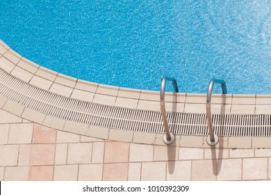 Edge Of Beautiful Luxury Swimming Pool With Grab Bars Ladder. Top View