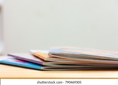 
Edge Book On The Wooden Table.  
Stack Magazines On Wood  Desk.    
School Education Concept.
(selective Focus )