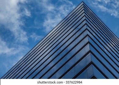 Edge of the Building/The corner of this commercial office building reflects the clouds above in the sky.
